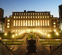 Alma Mater is backlit by the lights of Low Library at night